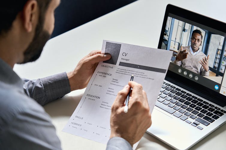 A man attending a virtual job interview using a laptop