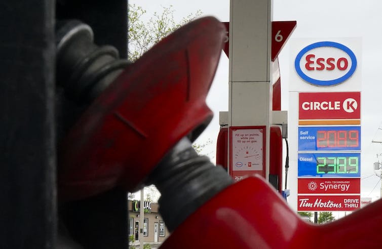 A close up photo of a gas pump with a gas price of 208.9 visible in the background