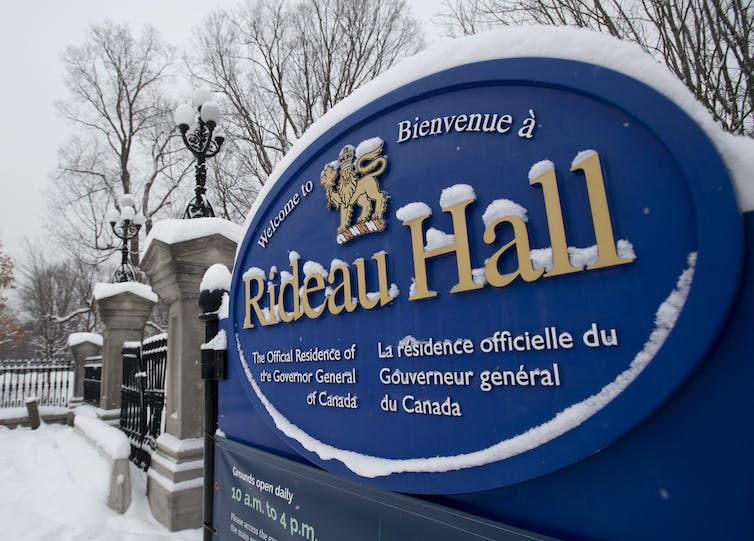 A blue snow-covered sign that says Rideau Hall in gold lettering