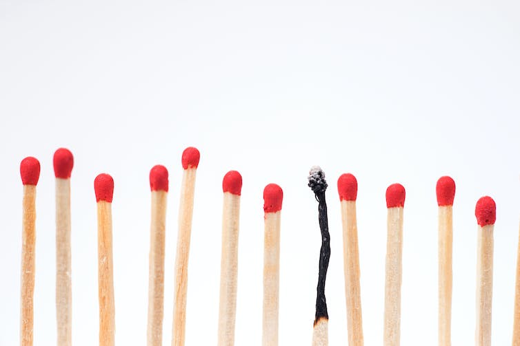 A row of matches with red tips, with one burnt up match