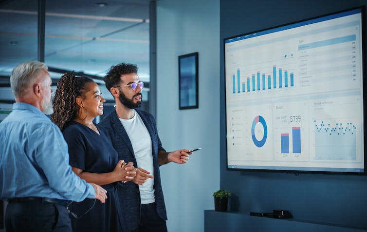 A group of people looking at a series of graphs projected on a screen