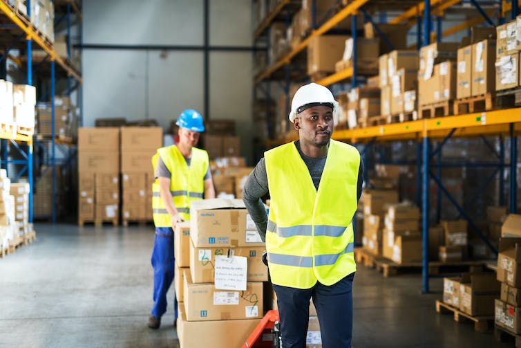 two warehouse workers with a pallet truck