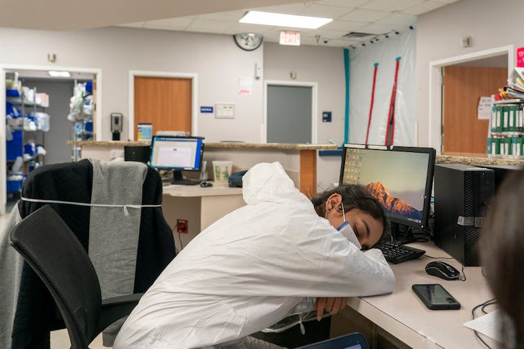 Health care worker sleeping at computer in nursing station