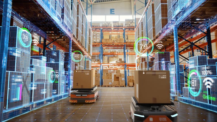 Automatic trolleys carry boxes along the aisle of a warehouse