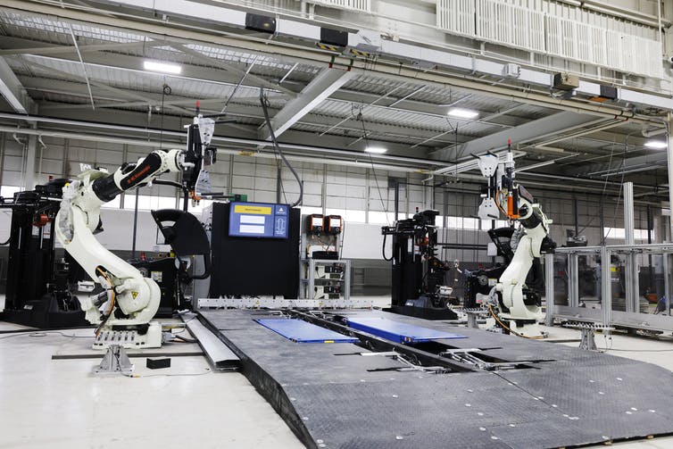 Two huge robotic arms sitting in a large, empty garage